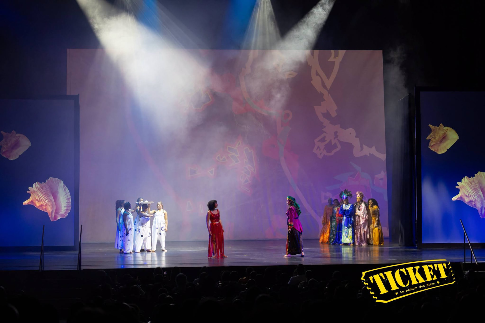 Full ensemble under spotlights with conch shell projections