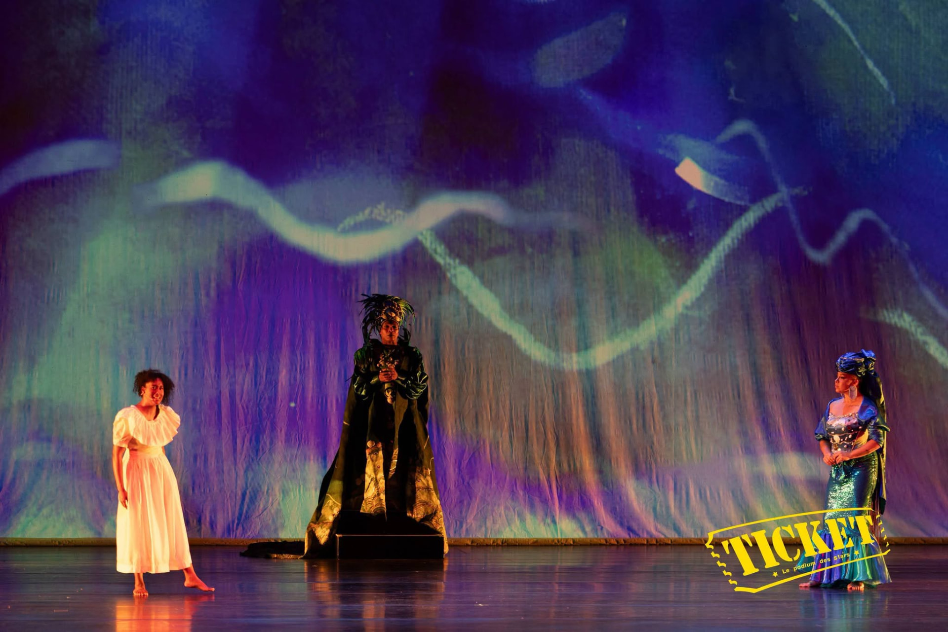 Three performers before a projected wave of light