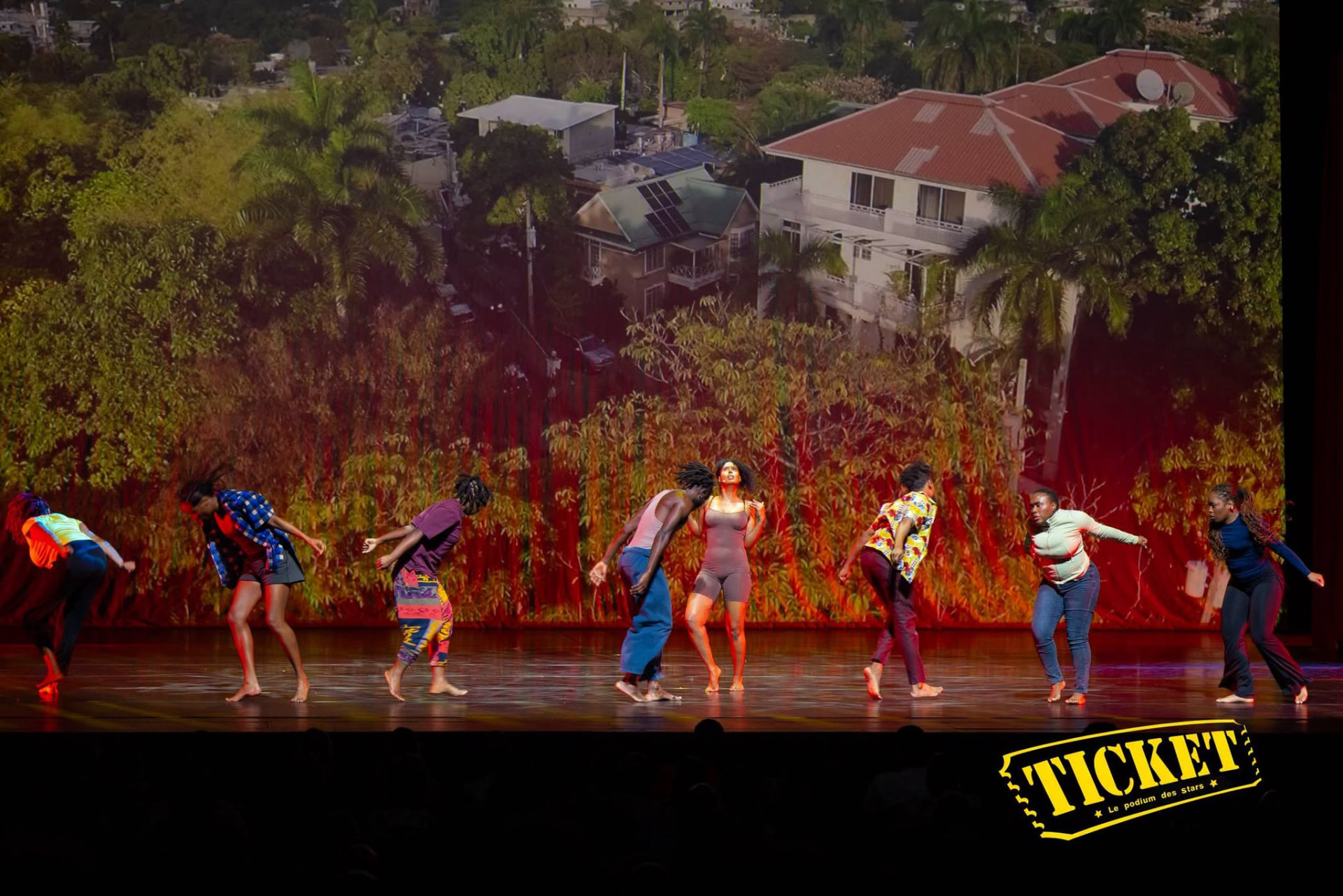 Dancers before a projected Haitian hillside landscape