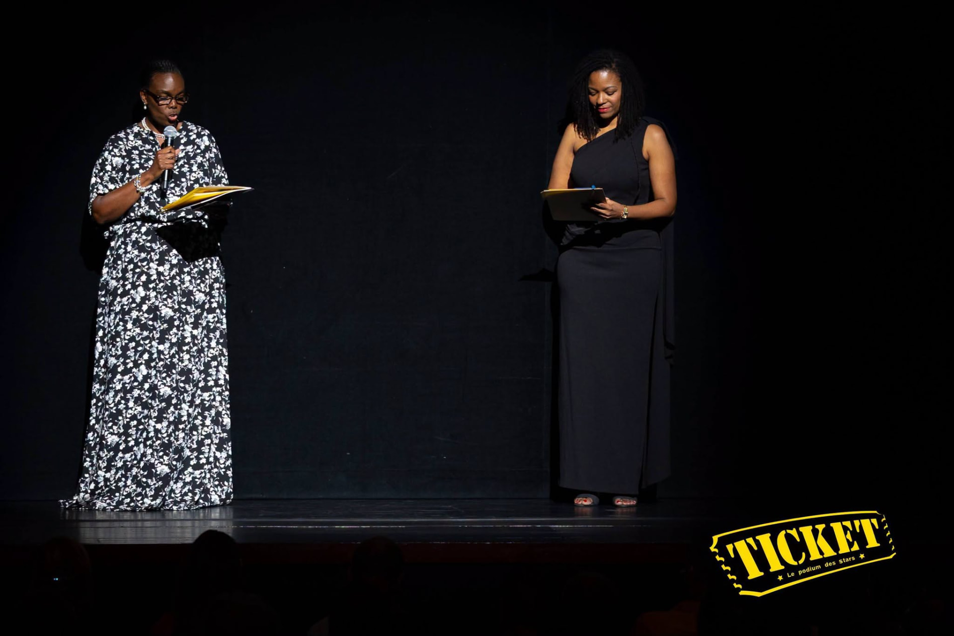 Two hosts addressing the audience from the stage