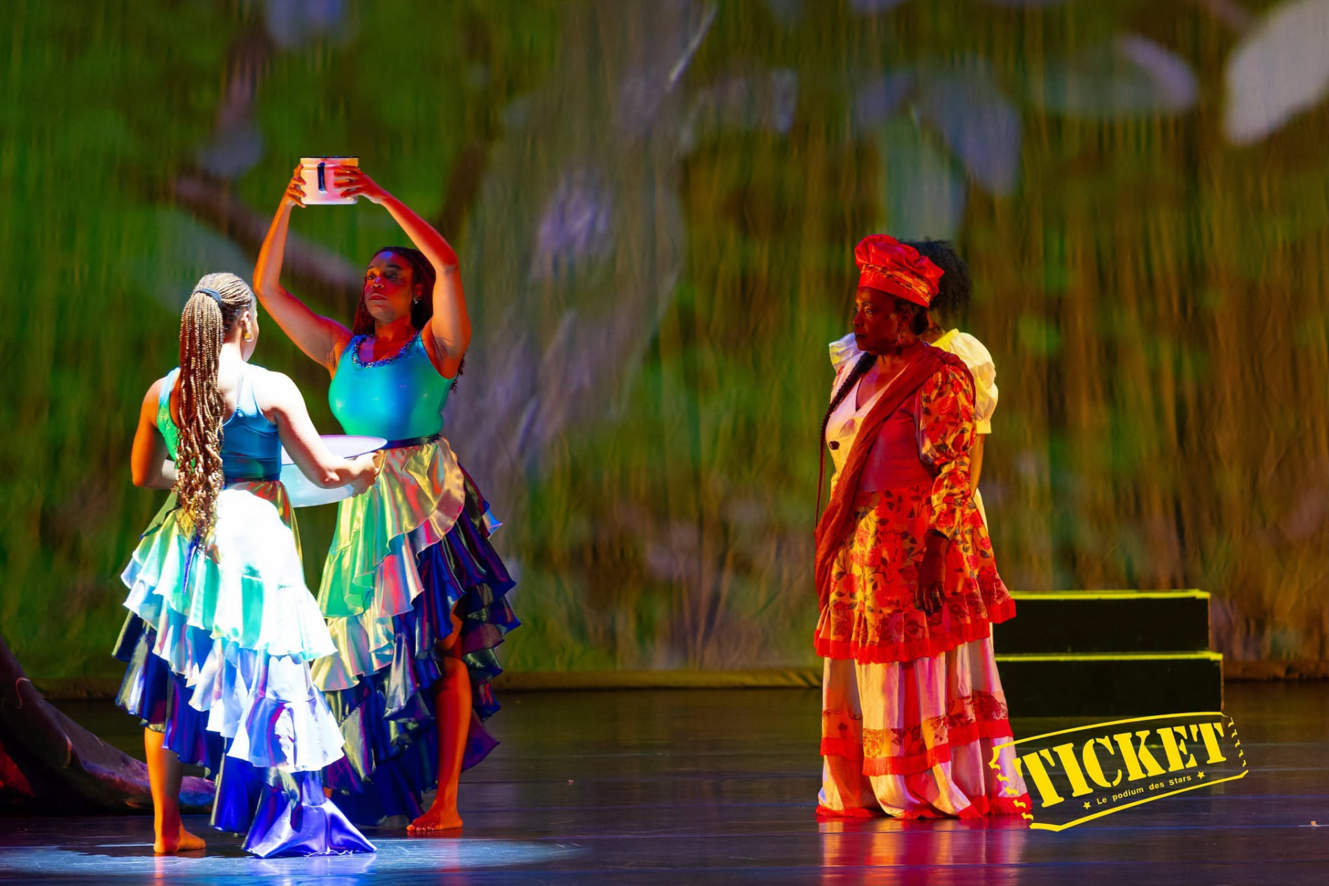 Dancers offering water beside a performer in red